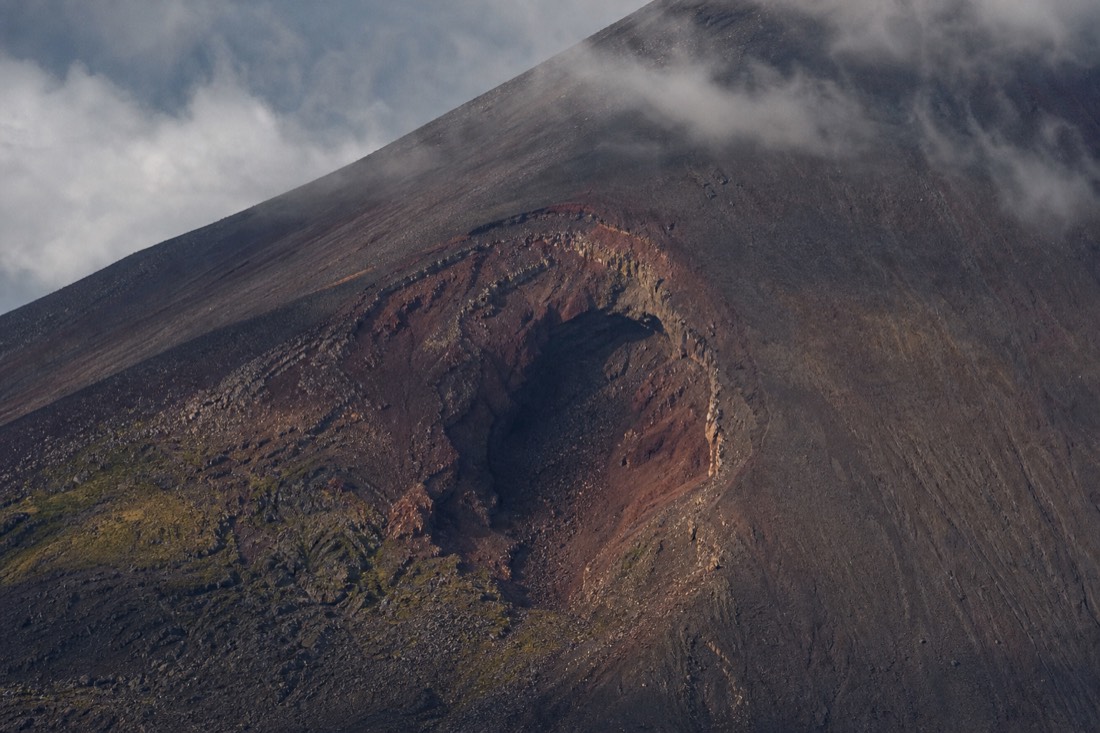 The ragged reddish crater scar on the southeastern flank of Mount Fuji seen through a telephoto lens
